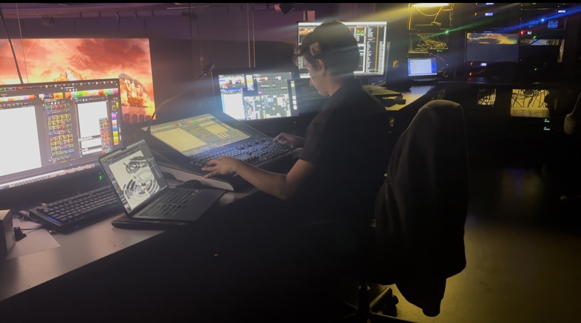 Xion programming a lighting console in a dark control room